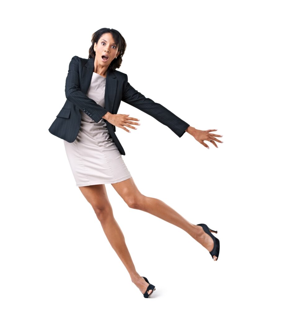 Accident-prone female executive falling over against a white background