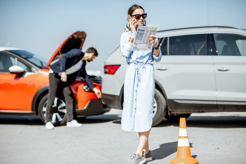 Woman calling with phone after the car collision